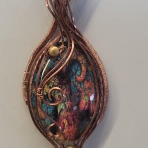 Glass cabachon wrapped in antique copper
